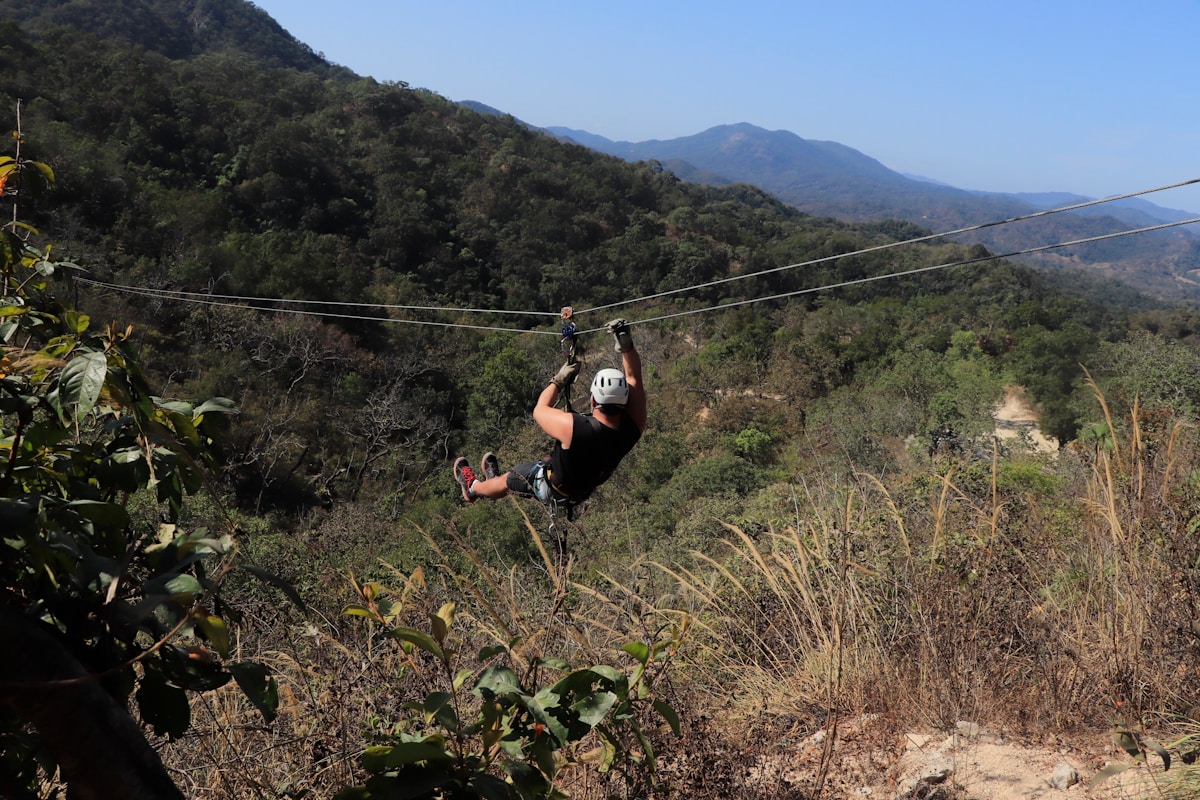Man zip-lining over a forested valley in the Sierra Madre, Puerto Vallarta, Mexico