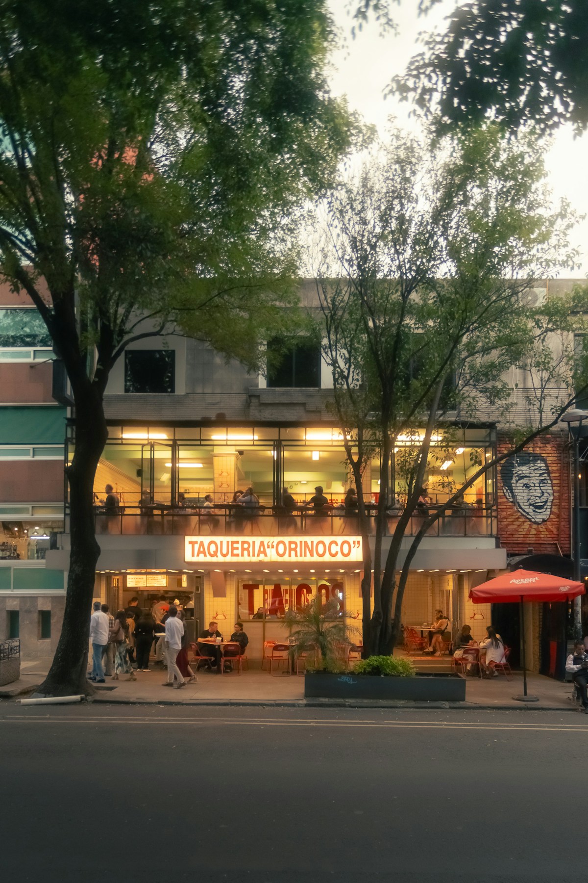 Taqueria Orinoco with diners outside on a tree-lined Mexico City street