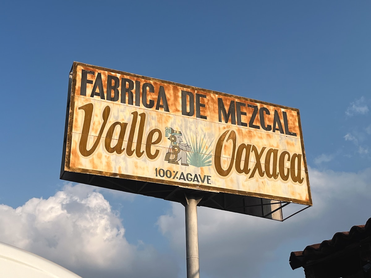Vintage Fabrica de Mezcal Valle Oaxaca sign against blue sky