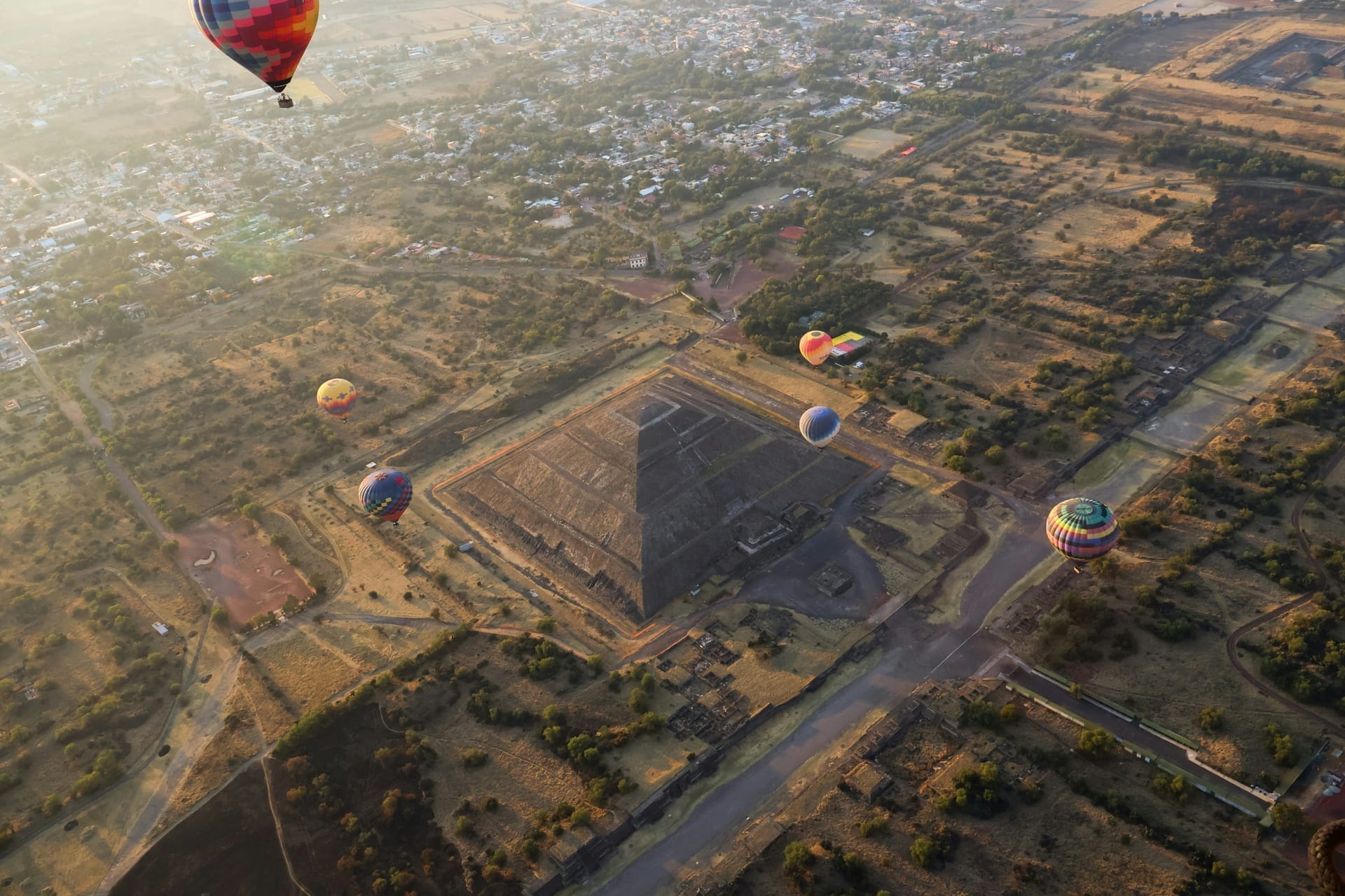 Hot air balloons floating over the Pyramid of the Sun at Teotihuacan, Mexico, at sunrise