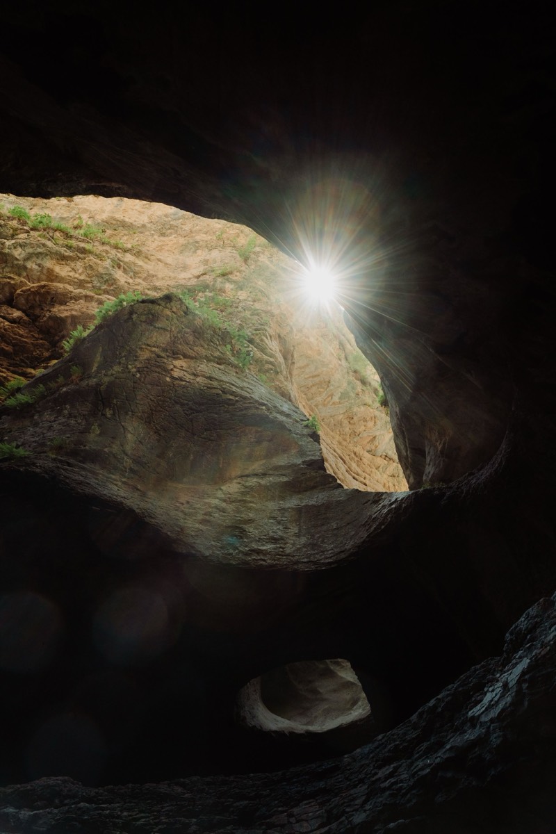 Sunlight beaming through a limestone cave opening into turquoise water, Yucatan Peninsula - like the underground river at Xcaret