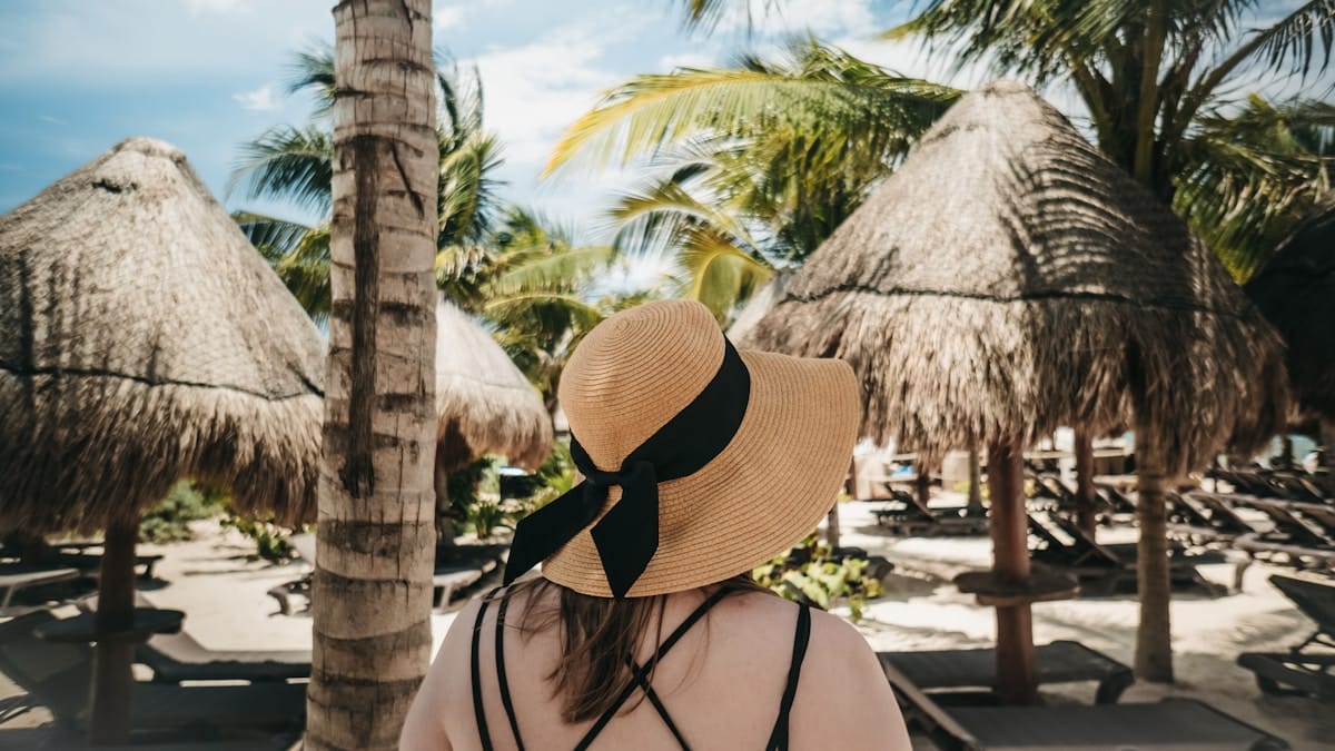 Woman in sun hat on Playa del Carmen beach — best time to visit Mexico