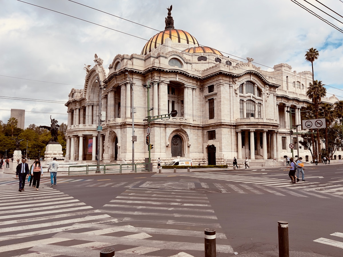 Palacio de Bellas Artes facade in Mexico City, white stone neoclassical architecture under cloudy sky