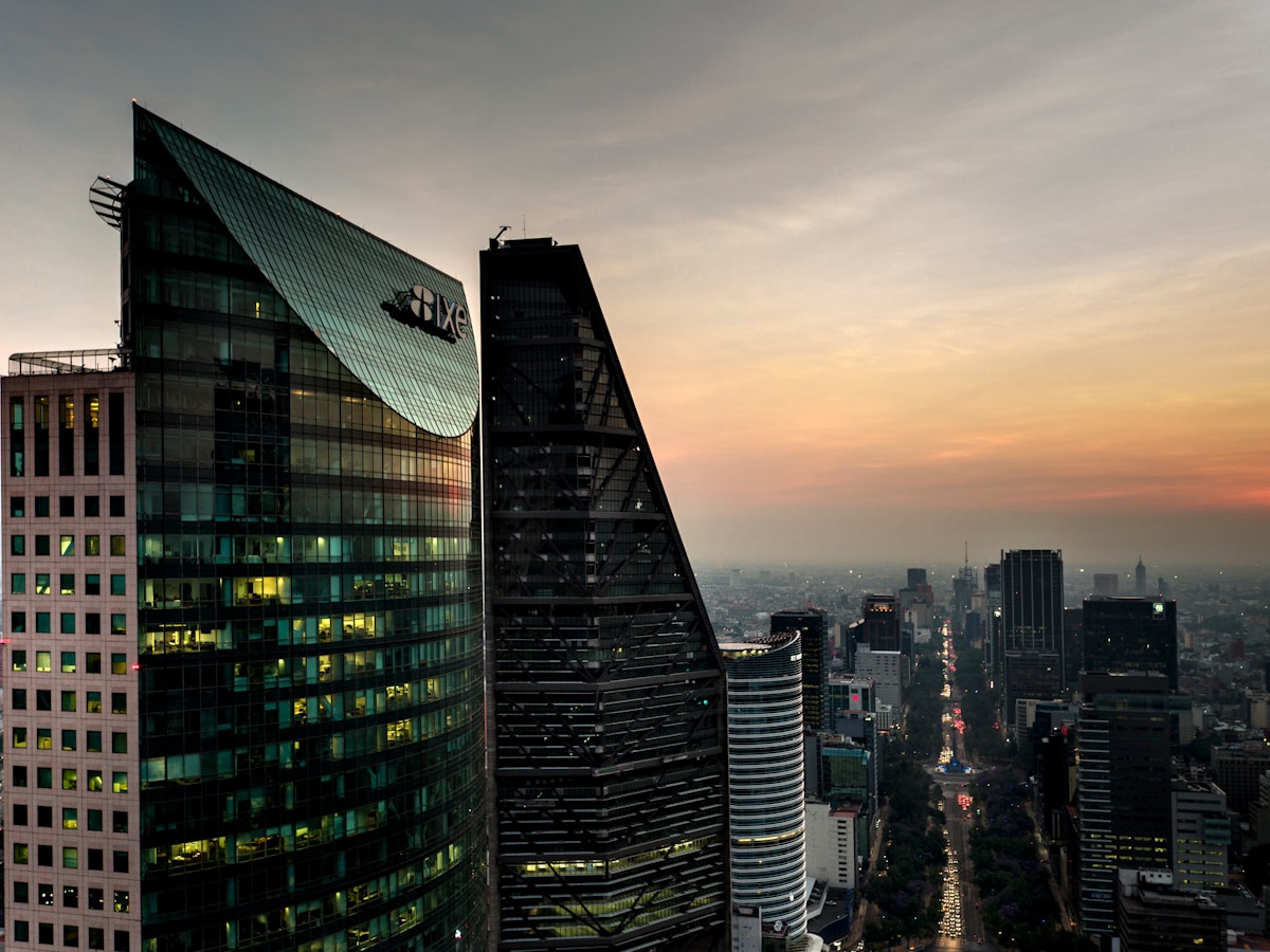 Mexico City skyscrapers at dusk with warm city lights and sunset glow over the Reforma financial district