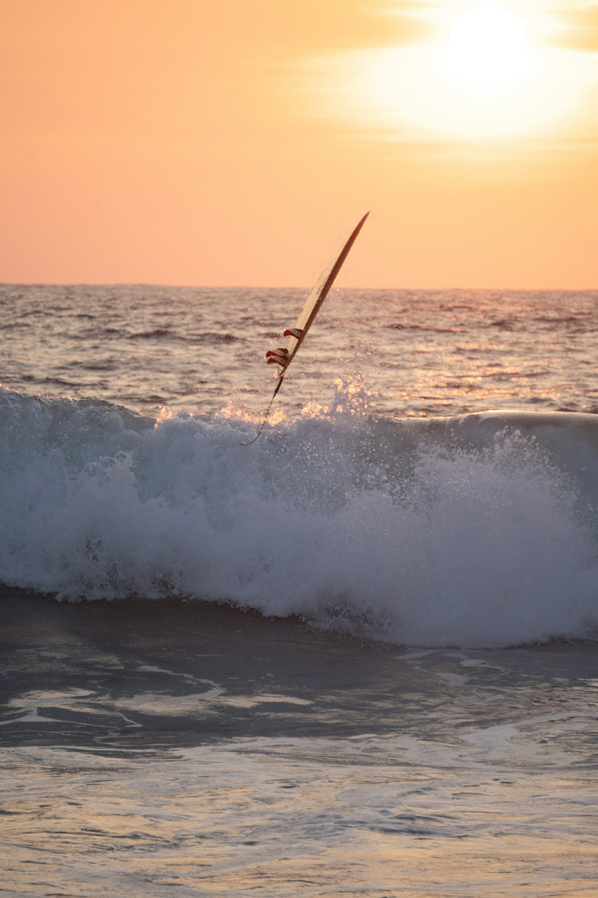Surfer performing an aerial manoeuvre on a large wave at sunset, Puerto Escondido, Oaxaca