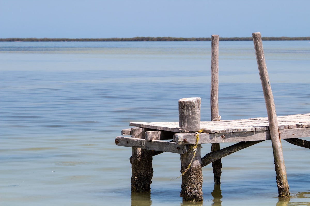 Weathered wooden dock extending over calm turquoise water, Isla Holbox, Quintana Roo