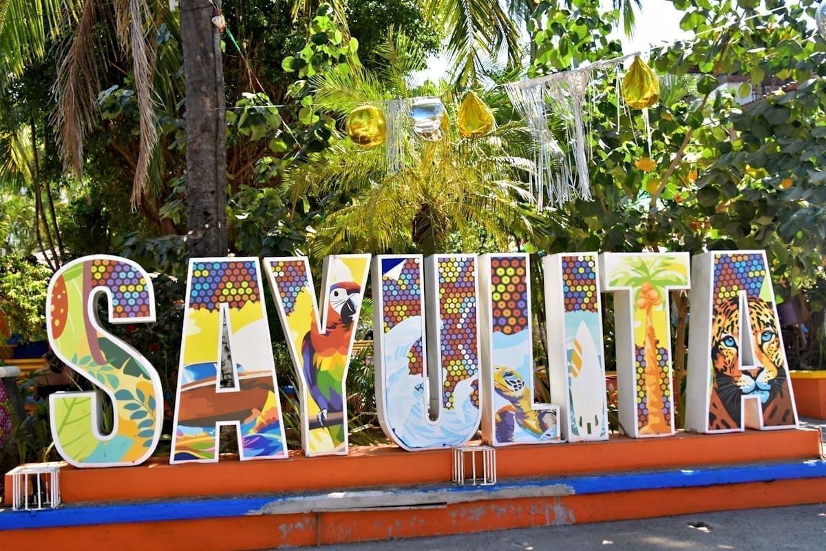 Colorful Sayulita sign with tropical palm trees and blue sky, Nayarit, Mexico