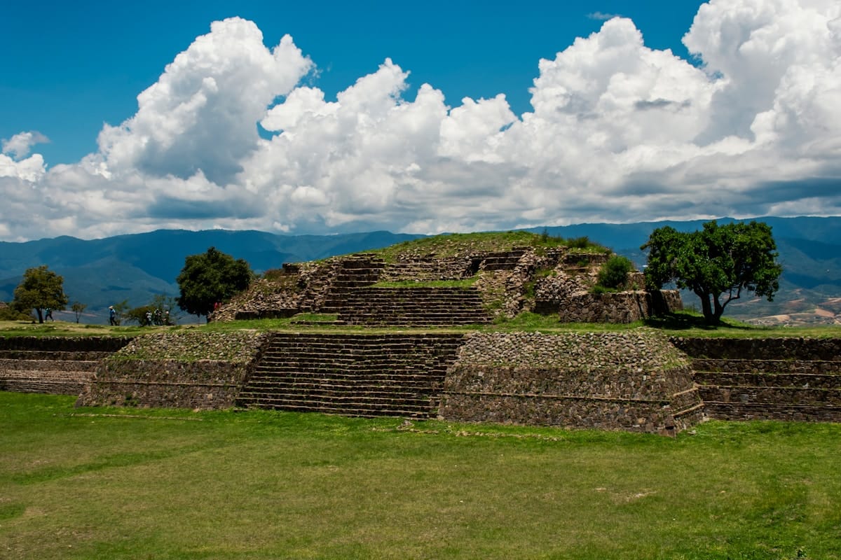 Monte Albán Zapotec ruins with stepped pyramid and Oaxaca valley mountains in the background
