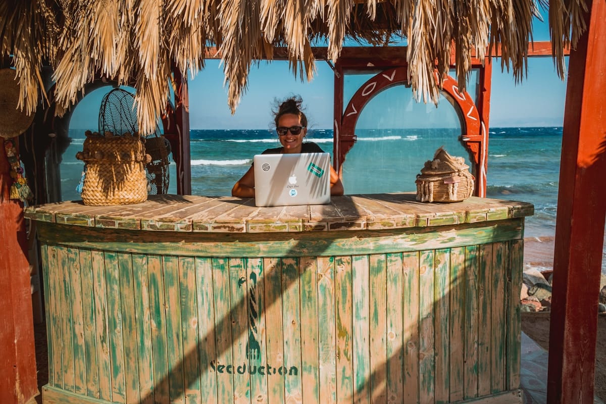 Laptop at tiki bar table — digital nomad in Playa del Carmen, Mexico