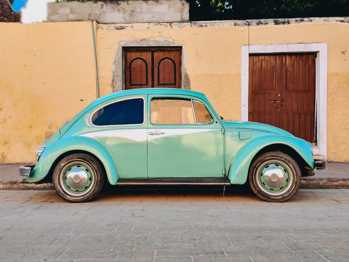 Teal Volkswagen Beetle on cobblestone street, Valladolid, Yucatan, Mexico