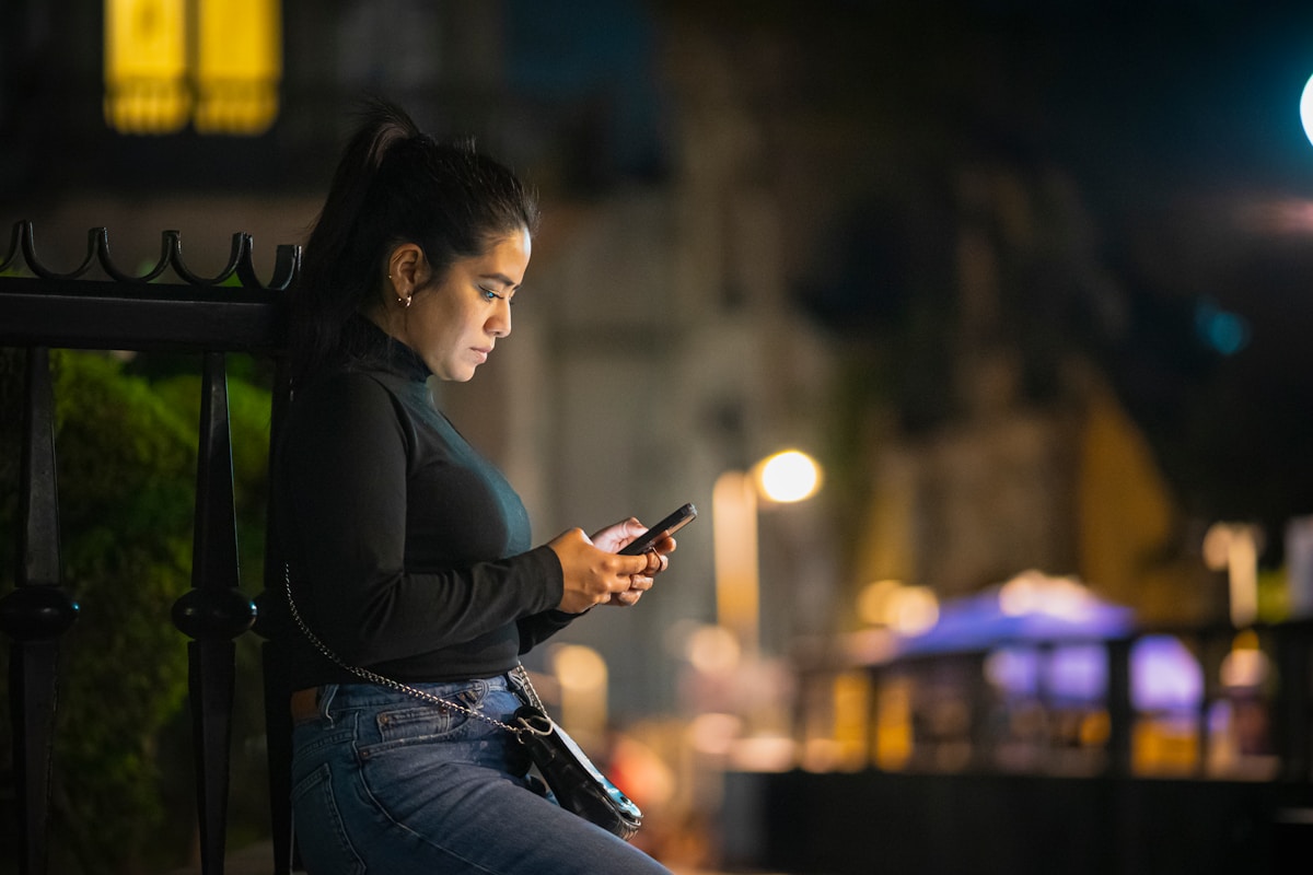 Woman using smartphone at night in Mexico City