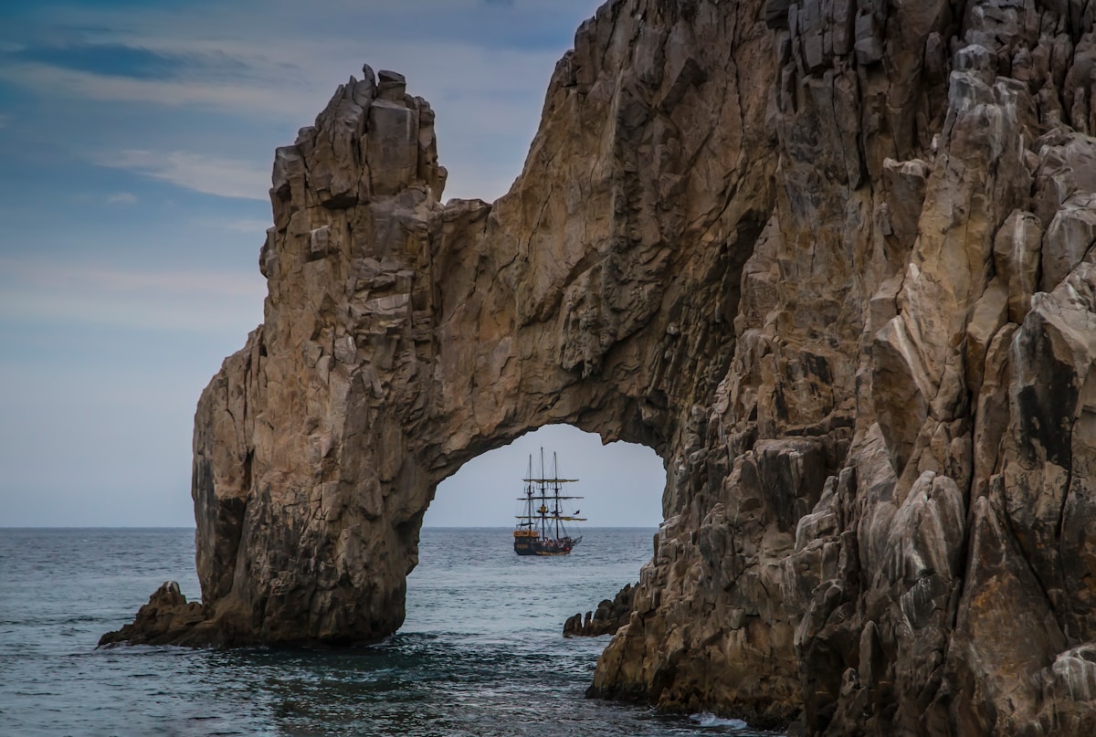 The rock arch of El Arco at Cabo San Lucas with a tall ship passing through, Baja California