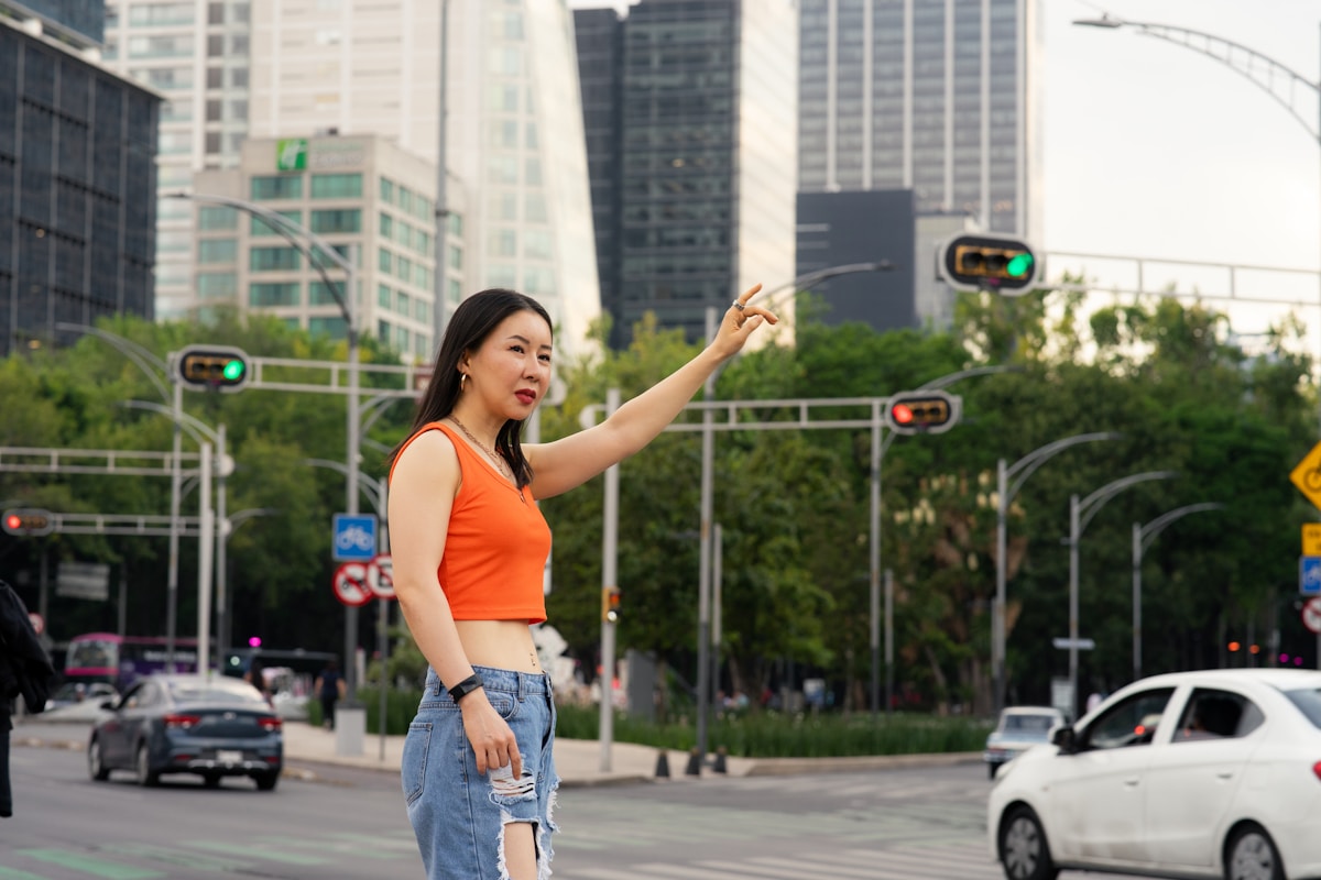 Woman hailing a taxi on a busy Mexico City boulevard