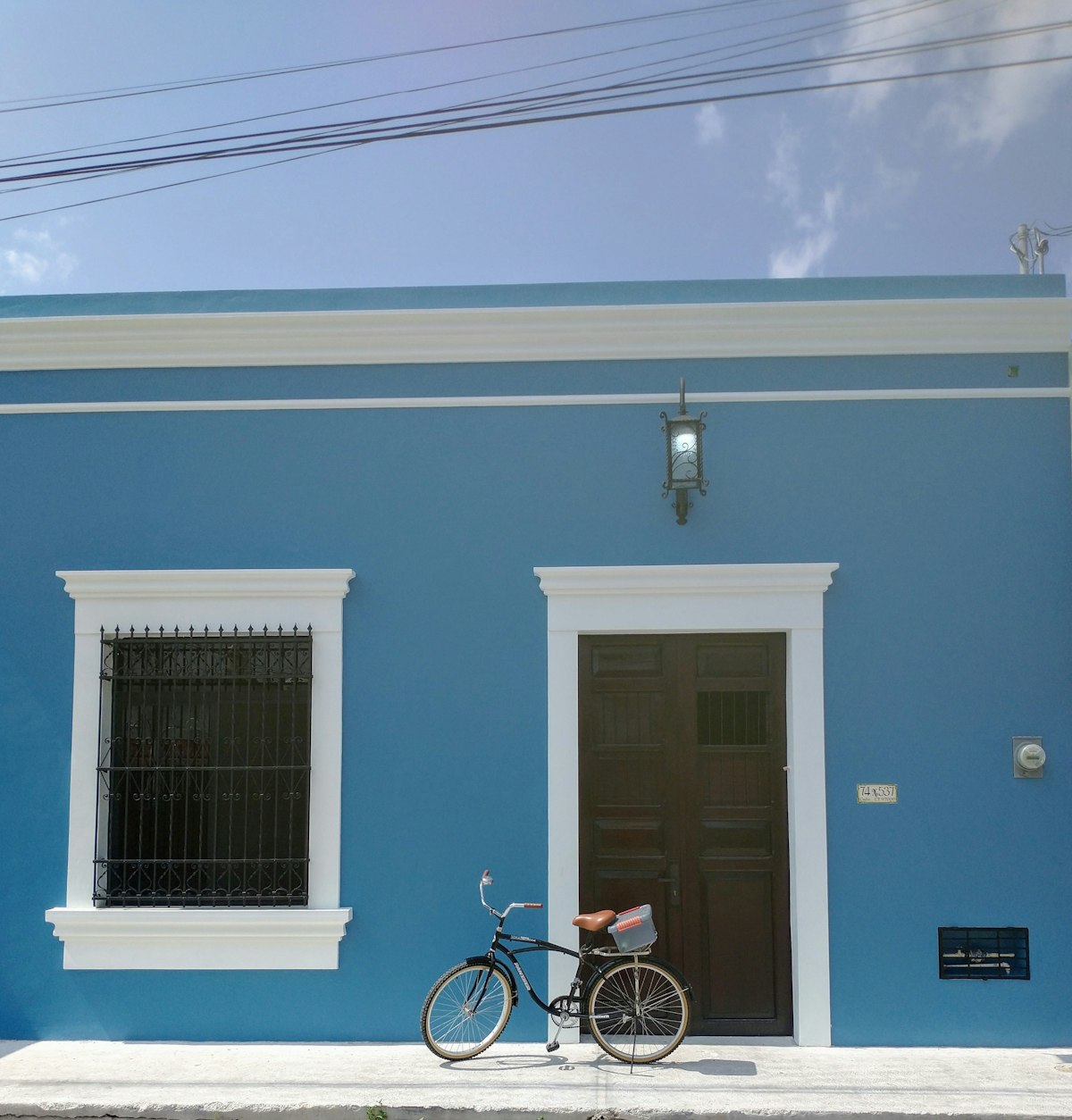 Bicycle parked in front of a blue colonial building in Mérida, Yucatán