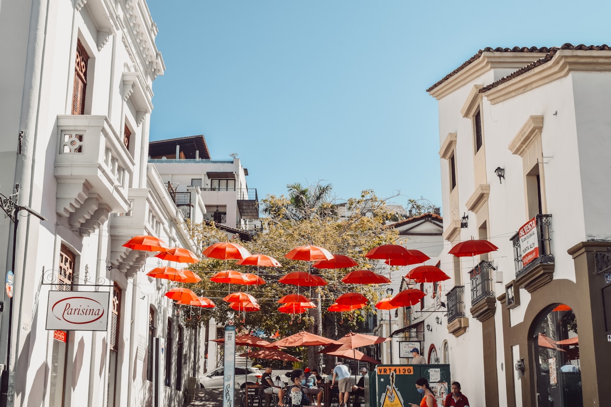 Pedestrian street in Puerto Vallarta old town with red umbrellas and colonial buildings