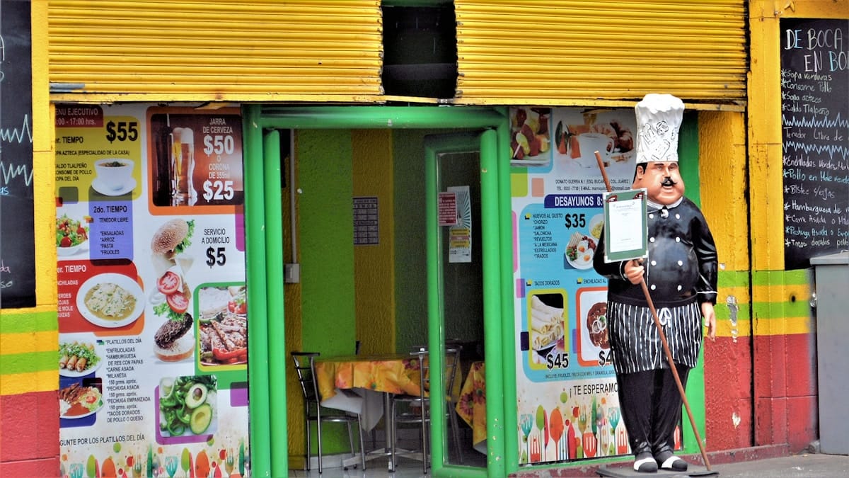 Woman at food stall in Mexico City, CDMX — vegan guide