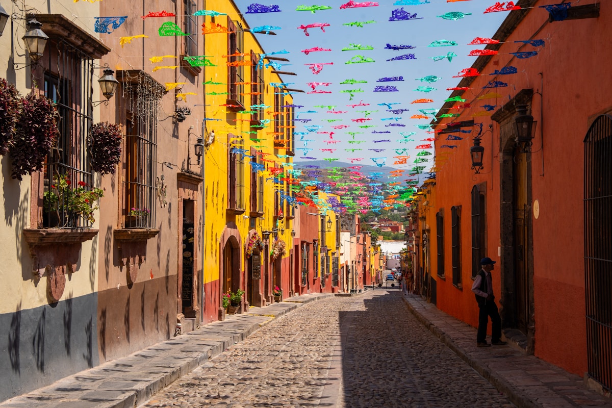 Cobblestone street with colourful flags and colonial buildings, San Miguel de Allende, Mexico